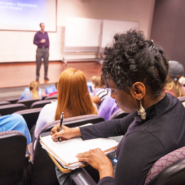 Girl takes notes in lecture