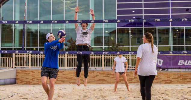 Students playing sand volleyball in front of the Recreation Center