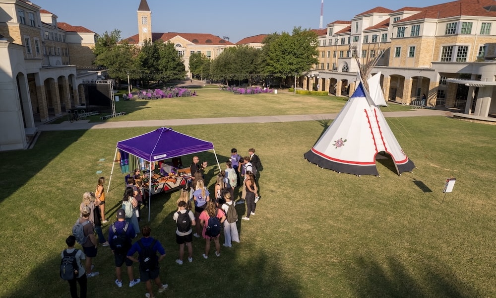 TCU Commons with students gathering near tipi in front of Frog Fountain
